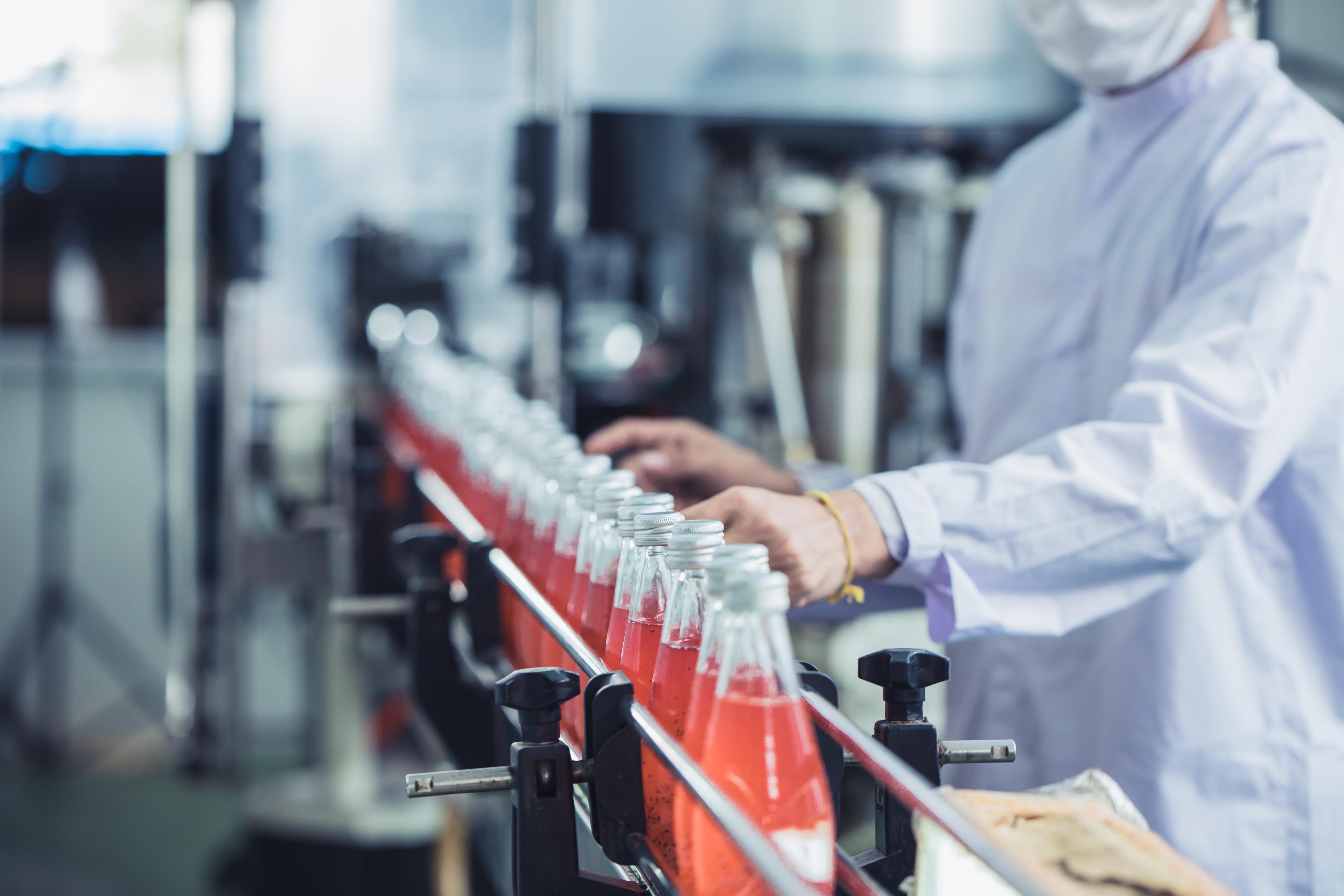 Drink factory - closeup hygiene worker working check juice glass bottled in production line